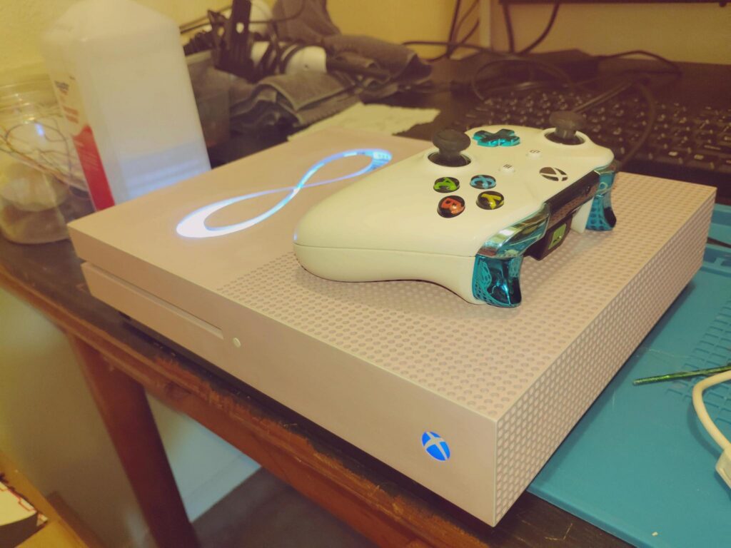 custom pink xbox one s with LED's and an infinity sign plexiglass window
